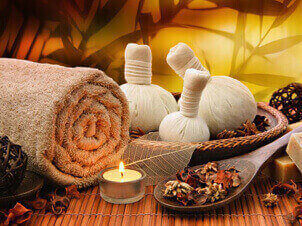 ayurvedic therapy including oils, towel and herbs