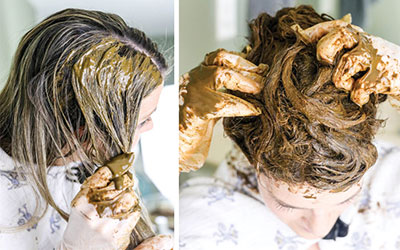 a women having herbal massaging on head hairs